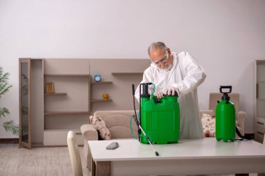 Yaşlı müteahhit evde haşere kontrolü yapıyor.