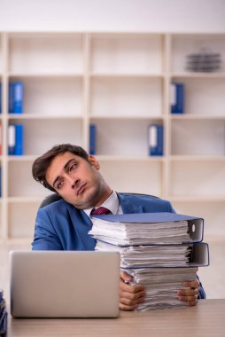 Genç işadamı ve işyerinde çok fazla iş var.