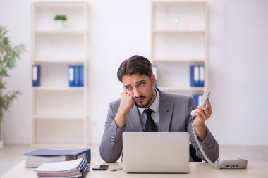 Genç işadamı işyerinde oturuyor.