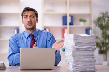 Genç işadamı ve ofiste çok fazla iş var.