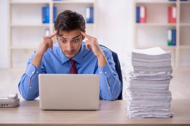 Genç işadamı ve ofiste çok fazla iş var.