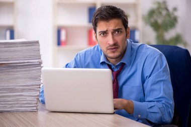 Genç işadamı ve ofiste çok fazla iş var.