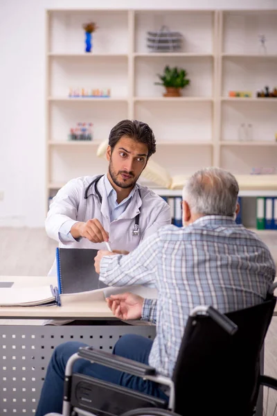Old Male Patient Wheelchair Visiting Young Male Doctor — Stock Photo, Image
