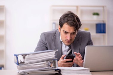 Ofisteki aşırı işten memnun olmayan genç bir çalışan.