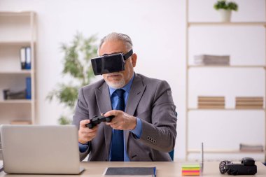 Eski işadamı ofiste sanal bardakların keyfini çıkarıyor.