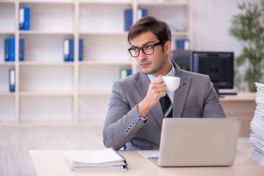 Genç işadamı ve ofiste çok fazla iş var.