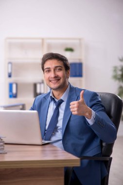 Genç bir erkek işçi ve işyerinde çok fazla iş var.