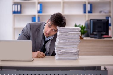 Genç işadamı ve ofiste çok fazla iş var.