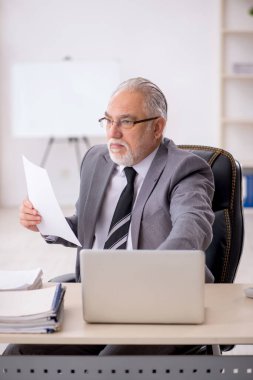 Ofiste çalışan eski bir işadamı.