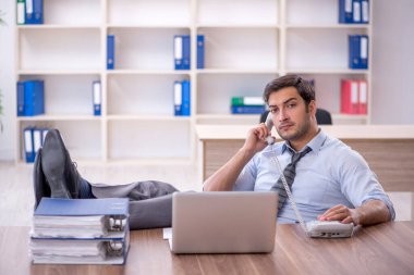 Ofisteki aşırı işten memnun olmayan genç bir çalışan.