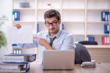 Ofisteki aşırı işten memnun olmayan genç bir çalışan.