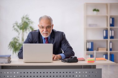 İş yerinde çalışan yaşlı bir işadamı