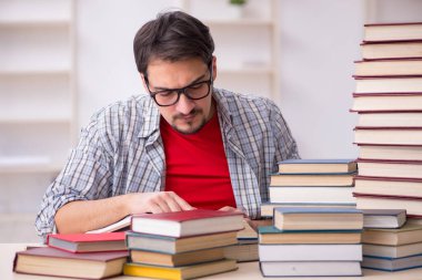 Genç bir öğrenci ve sınıfta çok fazla kitap var.