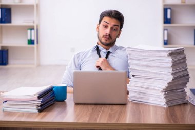 Ofisteki aşırı işten memnun olmayan genç bir erkek işçi.