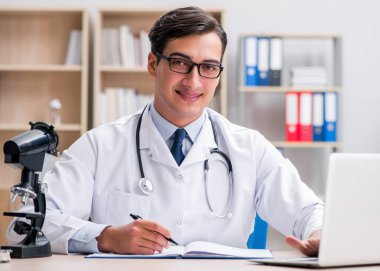 Dizüstü bilgisayarı olan genç bir doktor.