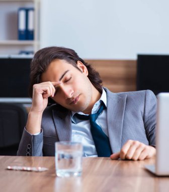 Ofiste acı çeken hasta erkek çalışan.