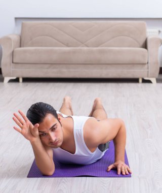 Genç adam evde antrenman ve egzersiz yapıyor.