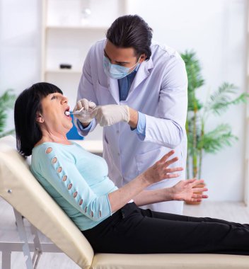 Yaşlı kadın genç dişçiyi ziyaret ediyor.