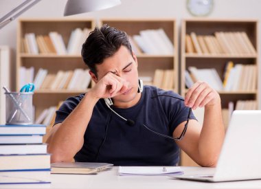 Genç serbest çalışan bilgisayar üzerinde çalışıyordu.