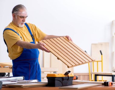 Atölyede çalışan yaşlı erkek marangoz.