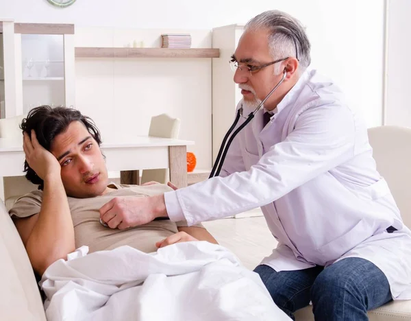 Der Alte Arzt Besuch Bei Jungen Männlichen Patienten — Stockfoto