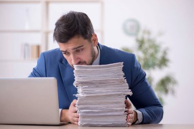 Genç bir çalışan ve ofiste çok fazla iş var.