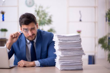 Genç bir çalışan ve ofiste çok fazla iş var.
