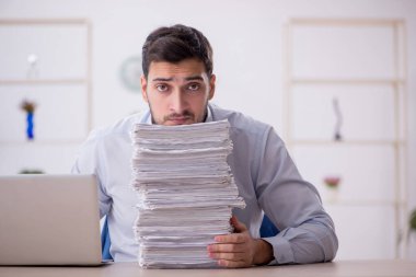Genç bir çalışan ve ofiste çok fazla iş var.