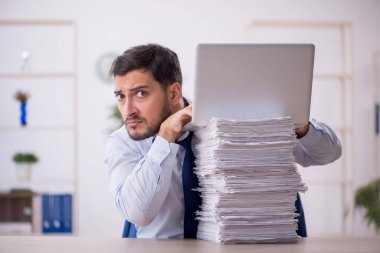 Genç bir çalışan ve ofiste çok fazla iş var.