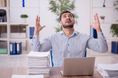 Genç işadamı ve işyerinde çok fazla iş var.