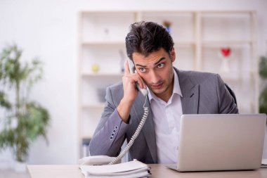 Genç işadamı ve ofiste çok fazla iş var.