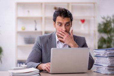 Genç işadamı ve ofiste çok fazla iş var.