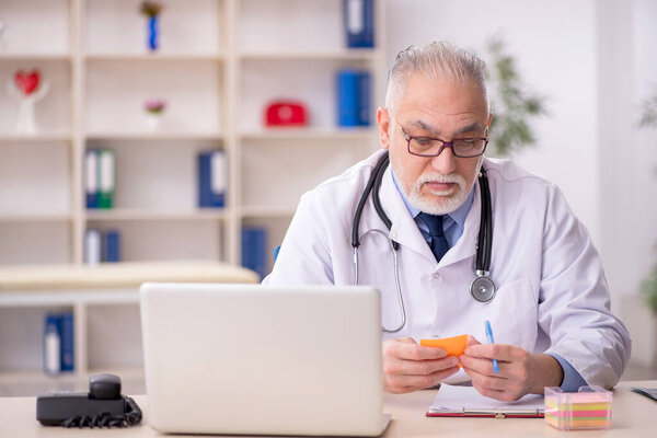 Old doctor working at the hospital
