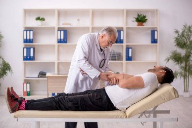 Young doctor visiting old doctor chiropractor