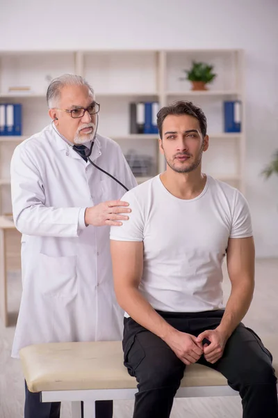 Young Patient Visiting Old Male Doctor — Stock Photo, Image