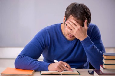 Sınıfta sınava hazırlanan genç bir öğrenci.