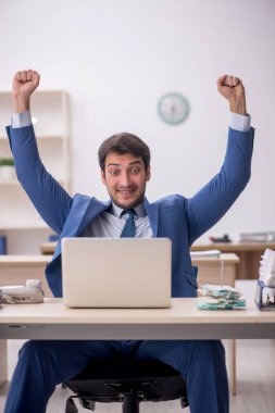 Genç erkek çalışan işyerinde oturuyor.