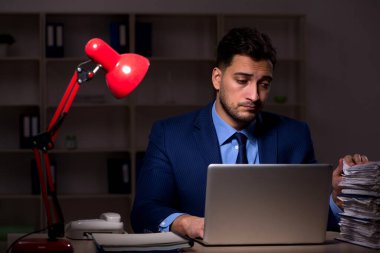 Young employee working late at workplace