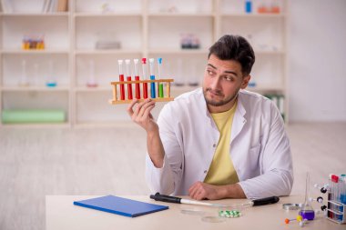 Young chemist sitting at the lab
