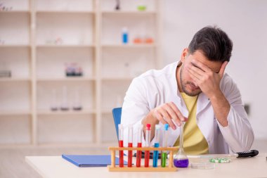 Young chemist sitting at the lab