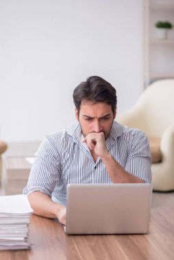 Young employee and too much work at workplace