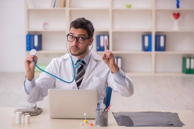 Young doctor holding phonendoscope at the hospital