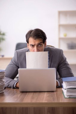 Genç işadamı ve işyerinde çok fazla iş var.