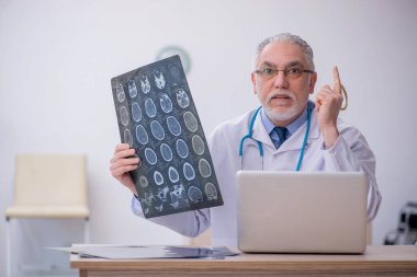 Hastanede çalışan yaşlı bir radyoloji uzmanı.