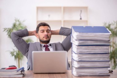 Genç bir çalışan ve ofiste çok fazla iş var.