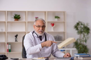 Klinikte çalışan yaşlı bir doktor.