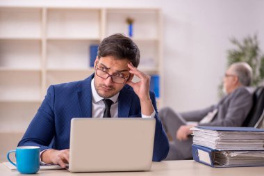 Eski patron ve genç çalışan ofiste.