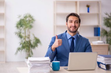 Genç işadamı ve işyerinde çok fazla iş var.