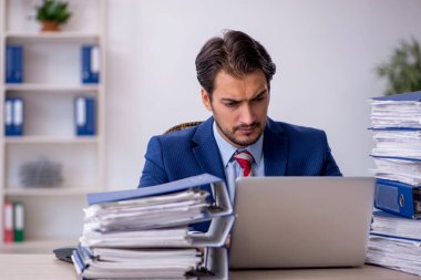 Genç işadamı ve ofiste çok fazla iş var.