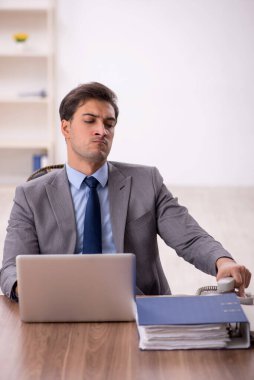 Genç işadamı işyerinde oturuyor.